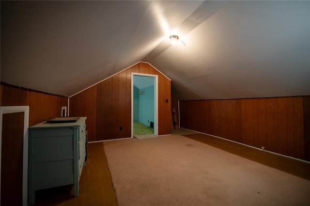 additional living space with lofted ceiling, wooden walls, and carpet floors