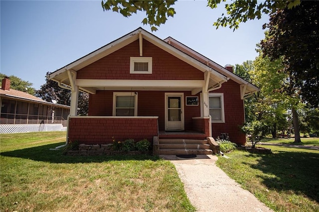 view of front of home with covered porch and a front lawn