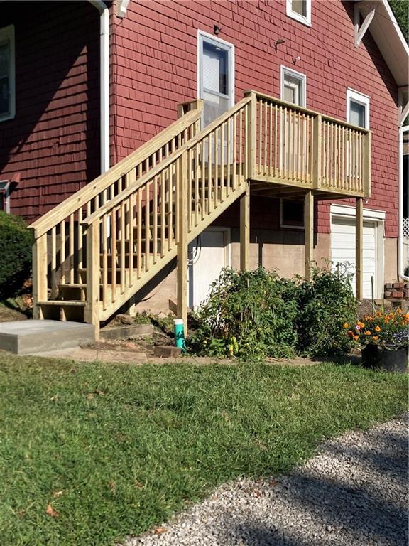 view of side of home featuring a wooden deck and a yard