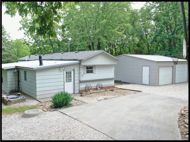 rear view of house with an outdoor structure and a garage