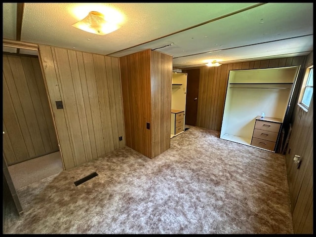 unfurnished bedroom with wood walls and a closet