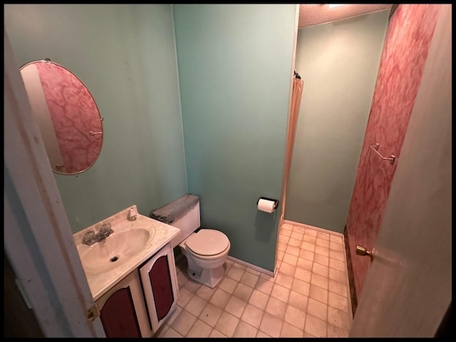 bathroom with tile patterned flooring, toilet, and vanity