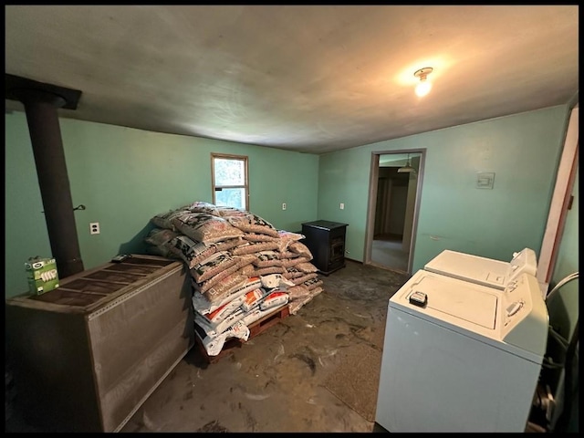 bedroom featuring a wood stove and independent washer and dryer