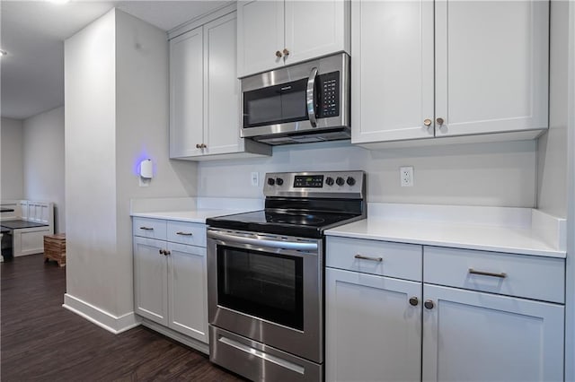 kitchen featuring white cabinets, dark hardwood / wood-style flooring, and appliances with stainless steel finishes