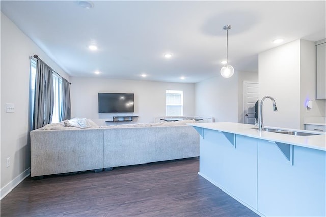 kitchen with a kitchen breakfast bar, dark hardwood / wood-style floors, hanging light fixtures, and sink