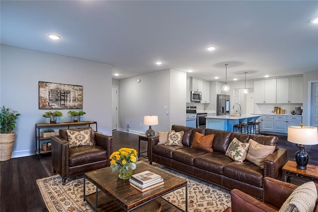 living room featuring dark wood-type flooring and sink