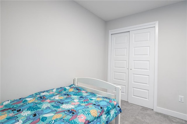 bedroom featuring light colored carpet and a closet