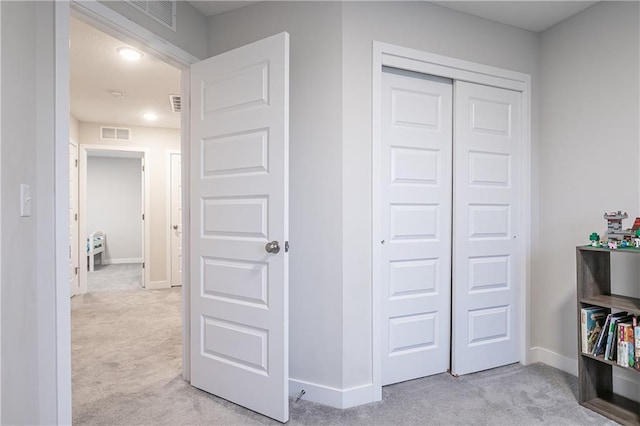 interior space featuring light carpet and a closet