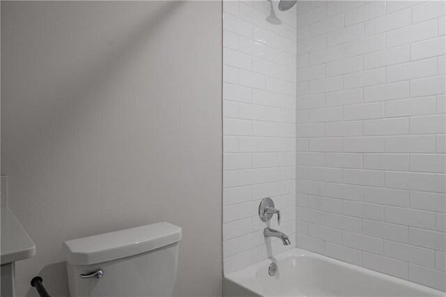 bathroom with toilet and tiled shower / bath