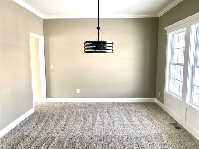 carpeted empty room featuring a chandelier and ornamental molding