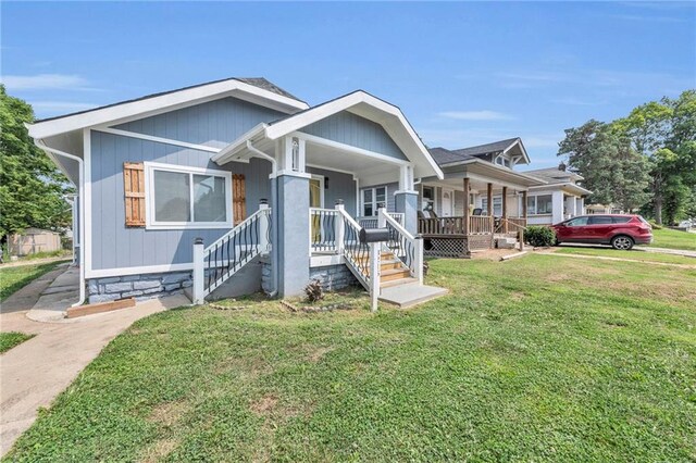 view of front of home with covered porch and a front lawn