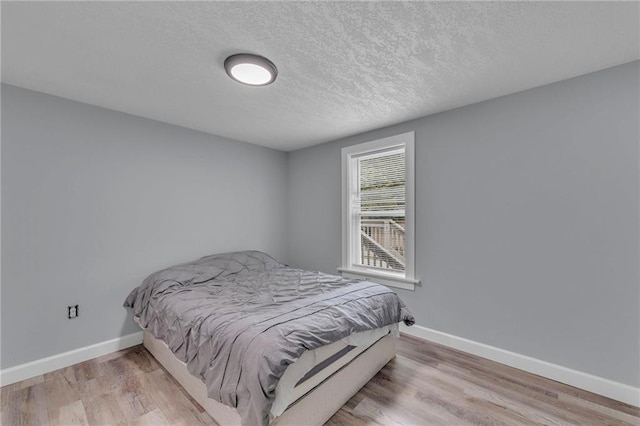 bedroom with wood-type flooring and a textured ceiling