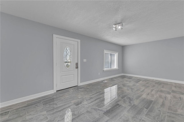 foyer entrance with a textured ceiling