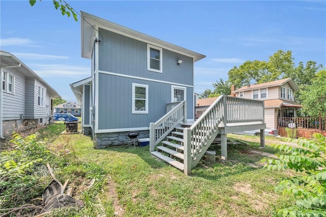 rear view of property featuring a yard and a deck