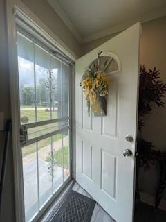 doorway to outside with ornamental molding