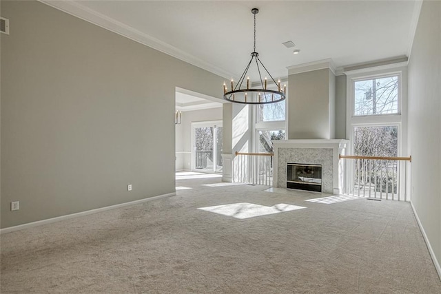 unfurnished living room featuring crown molding, carpet, and a chandelier