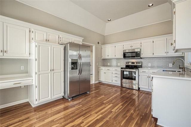 kitchen featuring appliances with stainless steel finishes, dark hardwood / wood-style floors, white cabinetry, sink, and backsplash