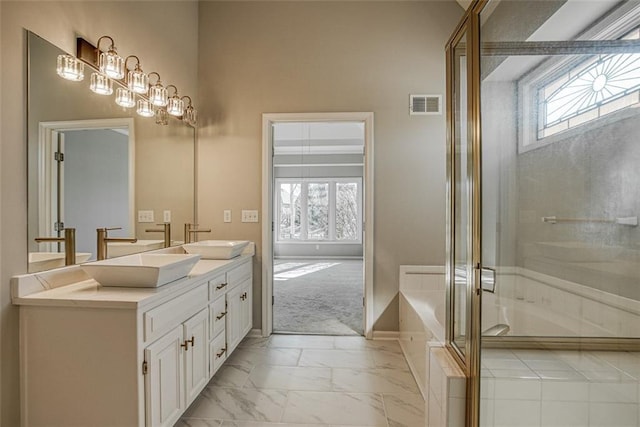 bathroom featuring walk in shower, a healthy amount of sunlight, and vanity