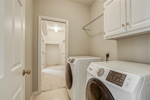 washroom with cabinets and washing machine and clothes dryer