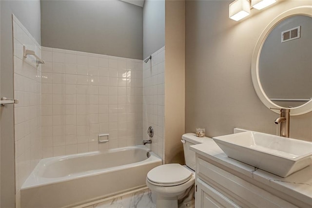 full bathroom with tiled shower / bath, vanity, and toilet