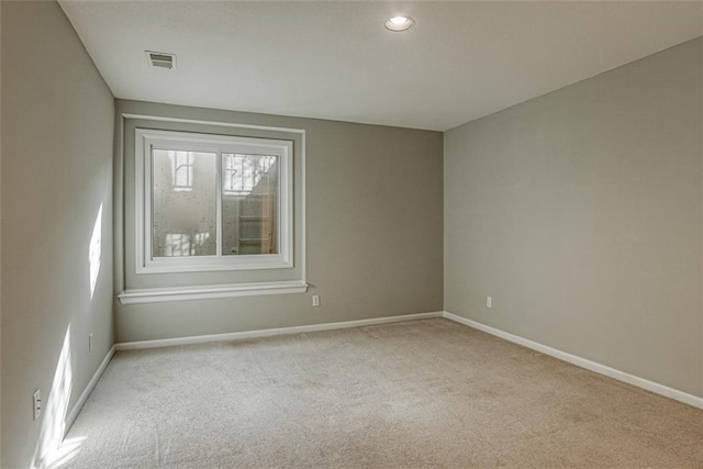 spare room featuring light colored carpet