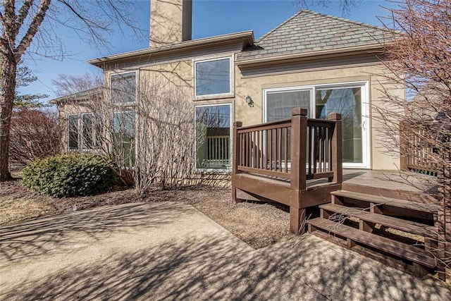 back of property featuring a wooden deck and a patio area