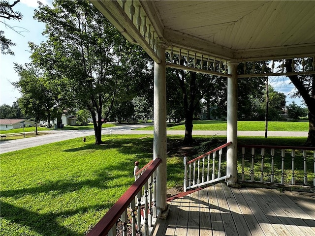 wooden terrace featuring a lawn