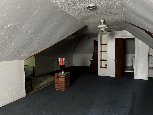 additional living space with a textured ceiling, ceiling fan, lofted ceiling, and carpet flooring