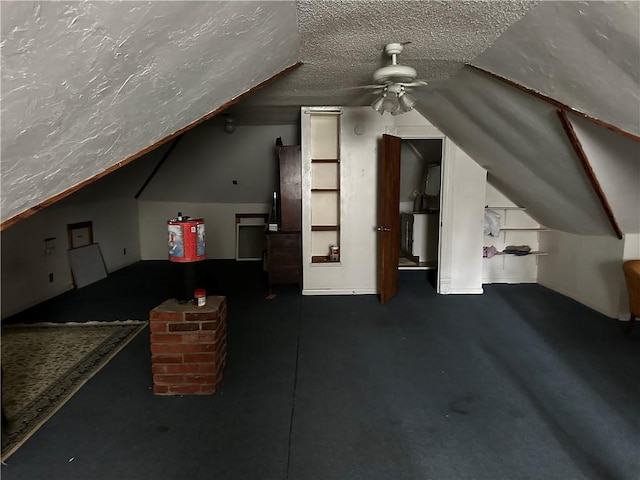 bonus room with a textured ceiling, ceiling fan, and vaulted ceiling