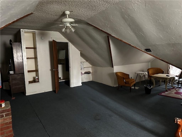 bonus room featuring a textured ceiling, carpet flooring, lofted ceiling, and ceiling fan