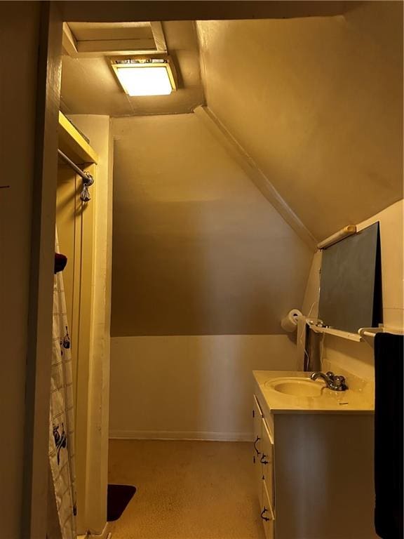 bathroom featuring vanity and lofted ceiling