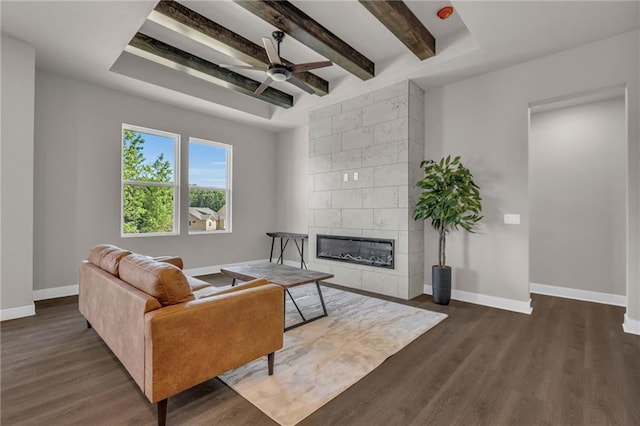 living room featuring beamed ceiling, tile walls, a tile fireplace, dark wood-type flooring, and ceiling fan