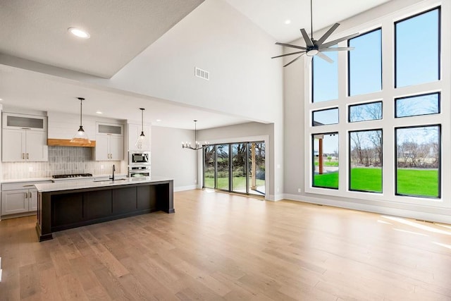 kitchen with open floor plan, light countertops, ceiling fan with notable chandelier, and appliances with stainless steel finishes
