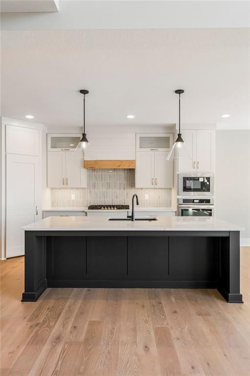 kitchen featuring light countertops, white cabinets, a sink, and stainless steel appliances