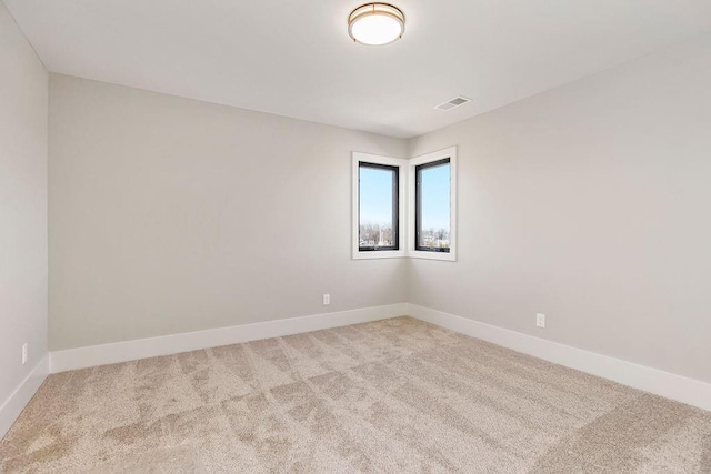 spare room with carpet, baseboards, and visible vents