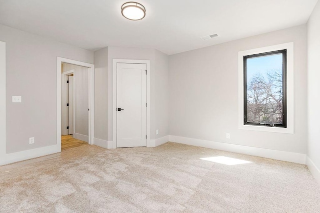 carpeted empty room with baseboards and visible vents
