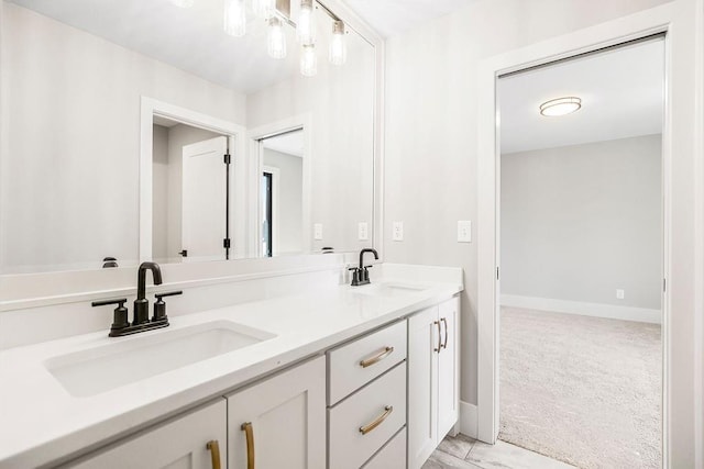 full bathroom featuring double vanity, a sink, and baseboards