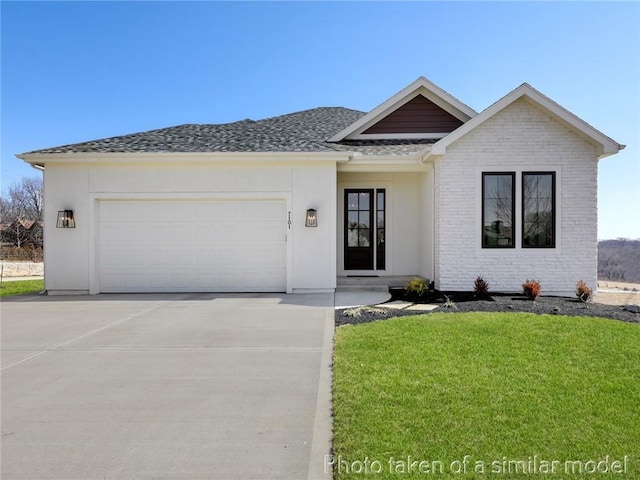 view of front of property with brick siding, a front yard, roof with shingles, driveway, and an attached garage