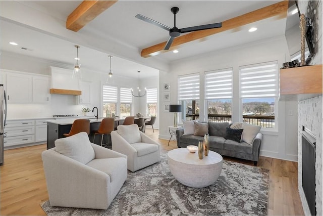 living room featuring light wood-type flooring, beamed ceiling, recessed lighting, baseboards, and ceiling fan