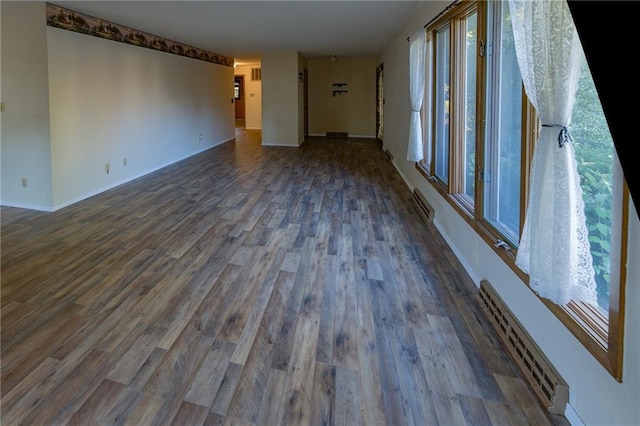 spare room with a baseboard radiator and dark hardwood / wood-style floors