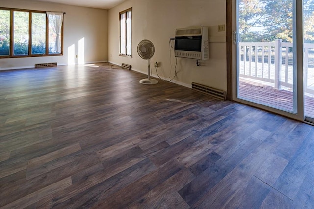 empty room featuring heating unit and dark hardwood / wood-style floors