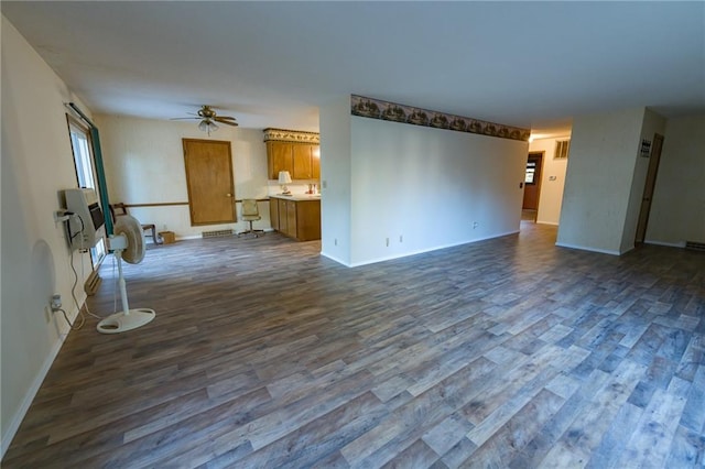 unfurnished living room featuring dark wood-type flooring and ceiling fan