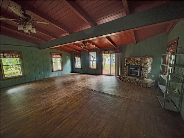 unfurnished living room with dark wood-type flooring, vaulted ceiling with beams, a fireplace, and ceiling fan