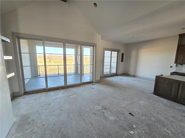 unfurnished living room featuring high vaulted ceiling