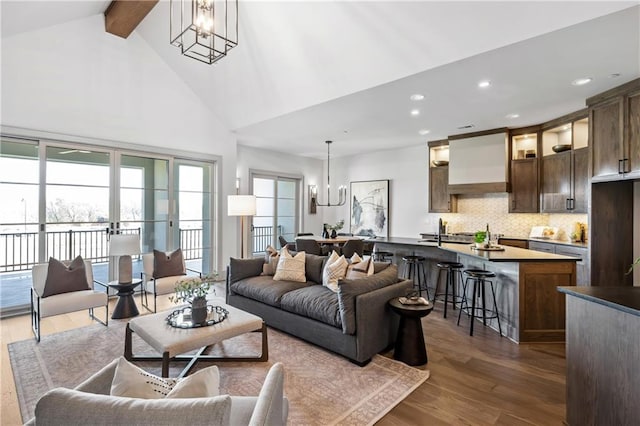 13707 Pembroke Ln, Leawood, KS 66224 - living room with high vaulted ceiling, a wealth of natural light, dark wood-style flooring, and a chandelier