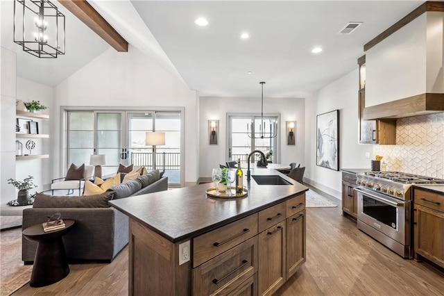 13707 Pembroke Ln, Leawood, KS 66224 - kitchen featuring a sink, dark countertops, high end stove, an inviting chandelier, and custom range hood