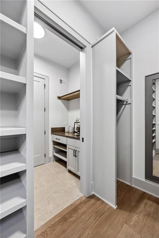 13707 Pembroke Ln, Leawood, KS 66224 - walk in closet with wood finished floors and visible vents