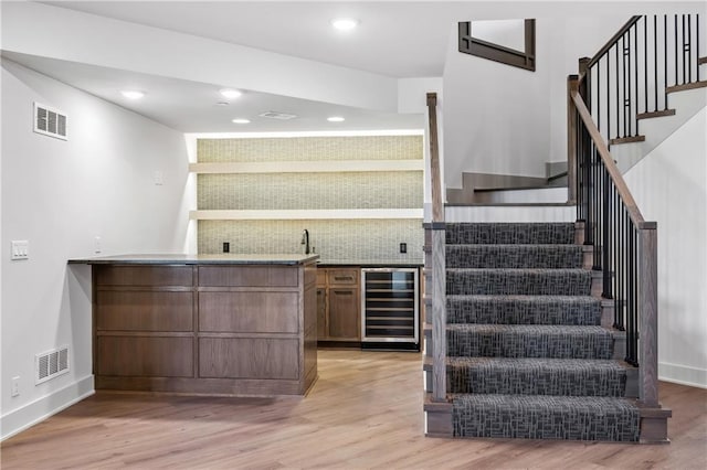 13707 Pembroke Ln, Leawood, KS 66224 - bar with beverage cooler, visible vents, and light wood finished floors