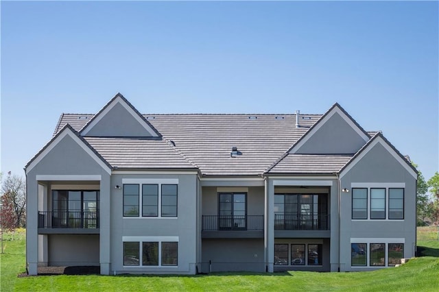 13707 Pembroke Ln, Leawood, KS 66224 - rear view of house featuring a yard, a balcony, and stucco siding