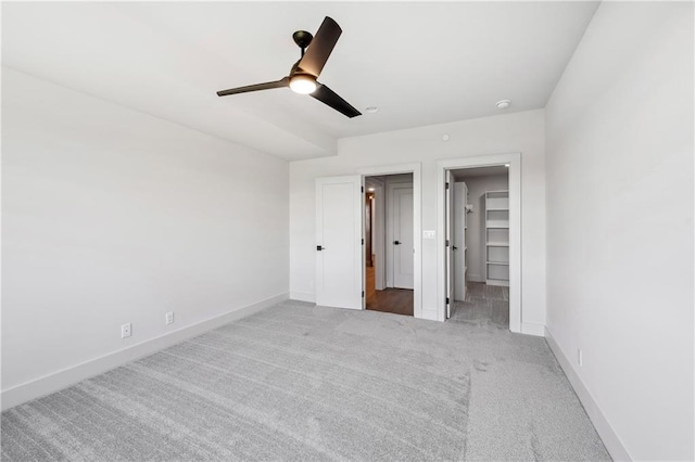 13707 Pembroke Ln, Leawood, KS 66224 - unfurnished bedroom with a ceiling fan, baseboards, carpet, and a walk in closet